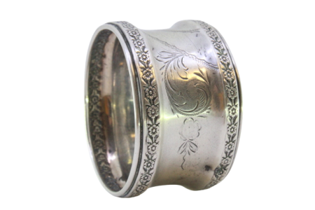 Argola de guardanapo em prata com motivos florais gravados envolvendo cartela para monograma.